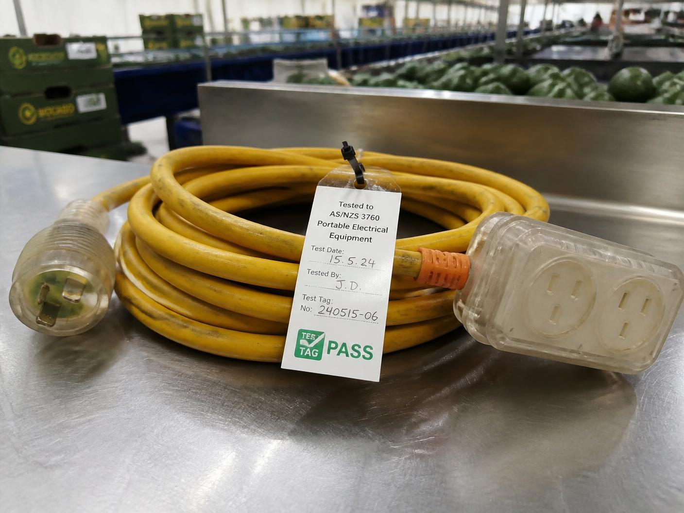 Coiled extension lead on a packhouse bench with a completed test tag attached